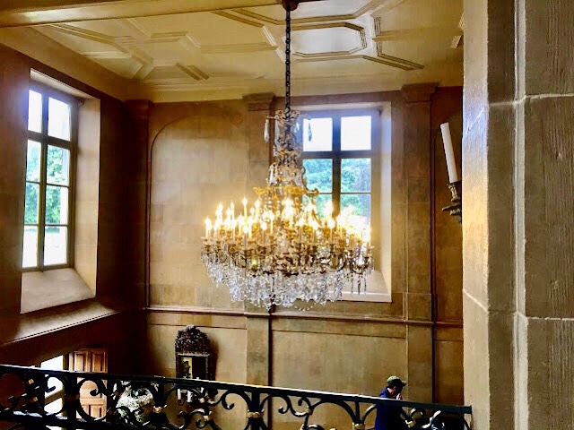 « Un lustre en bronze doré et cristal de Baccarat dans le château de Modave »